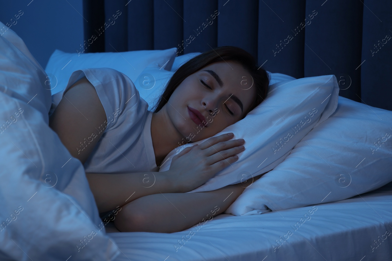 Photo of Beautiful young woman sleeping in bed at night