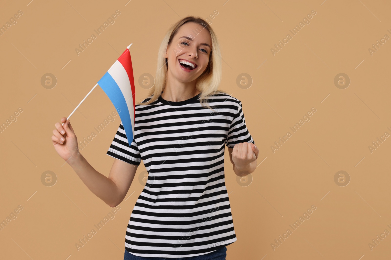 Photo of Happy woman with flag of Netherlands on beige background, space for text