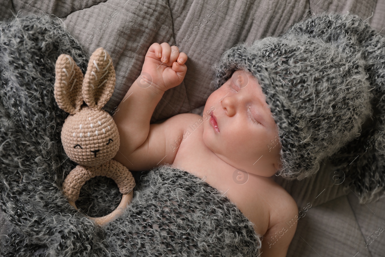 Photo of Cute newborn baby sleeping with teething toy in bed, top view