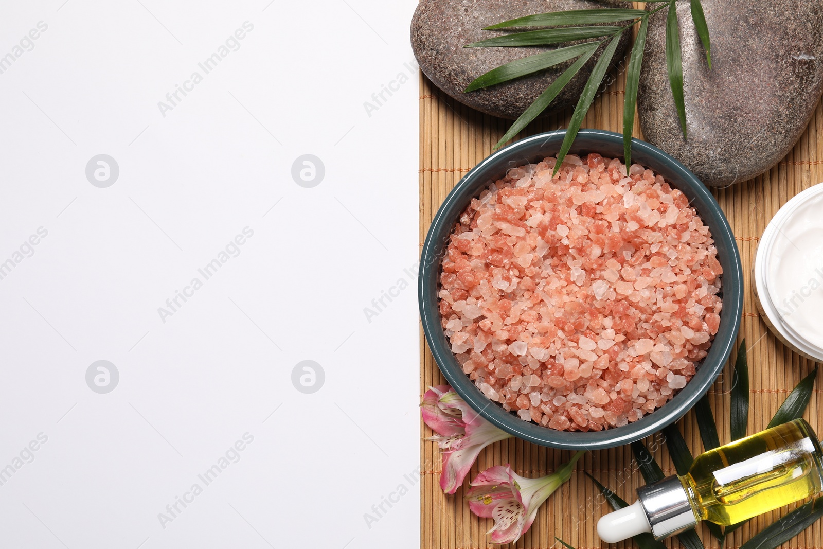 Photo of Flat lay composition with natural sea salt on white background. Space for text