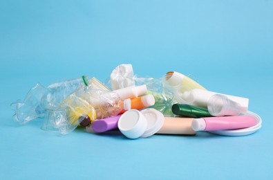 Photo of Pile of plastic garbage on light blue background