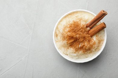 Delicious rice pudding with cinnamon on light table, top view. Space for text