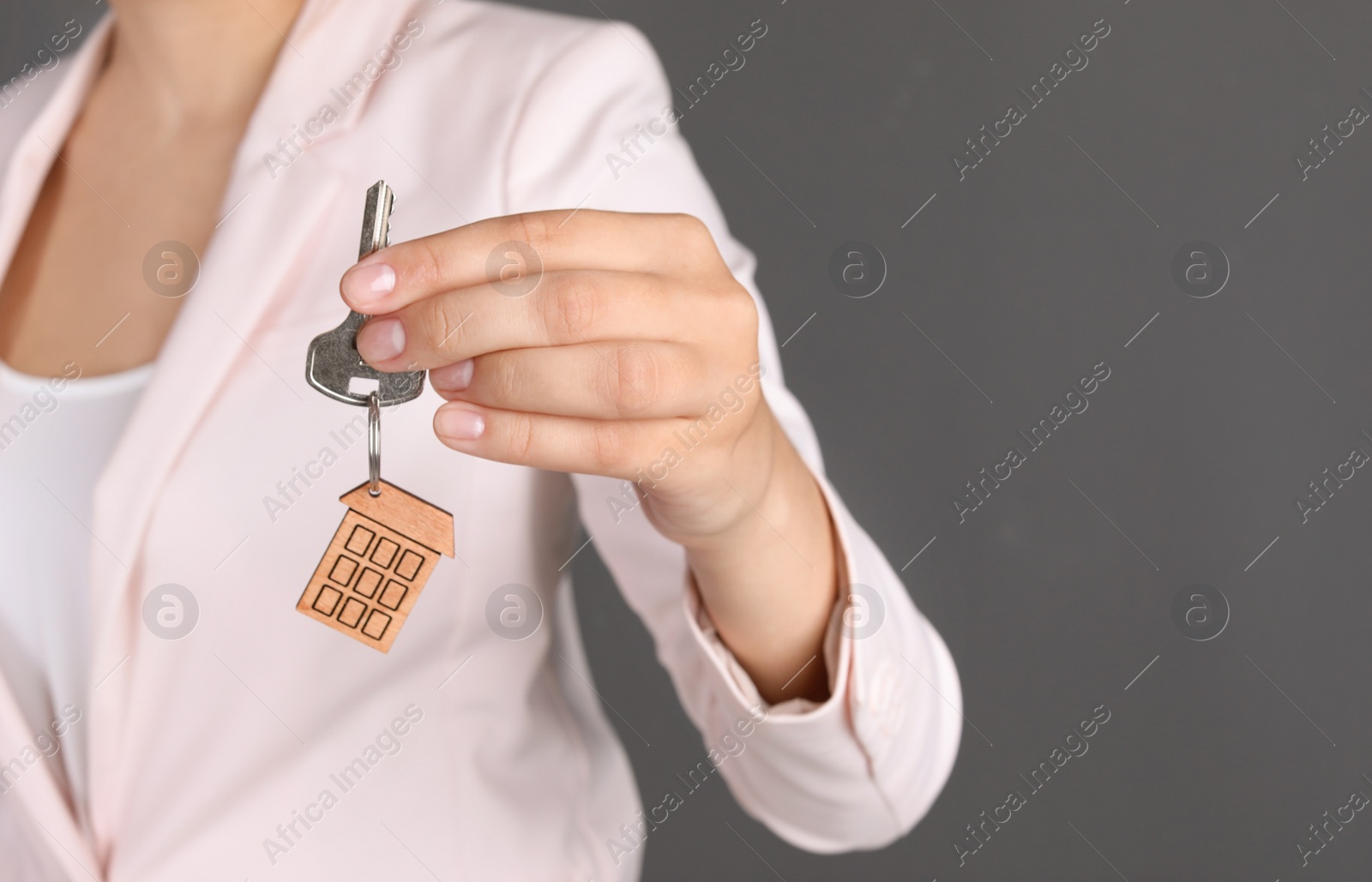 Photo of Real estate agent with key on gray background
