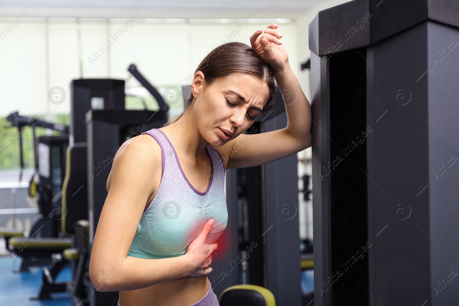 Photo of Young woman having heart attack in gym