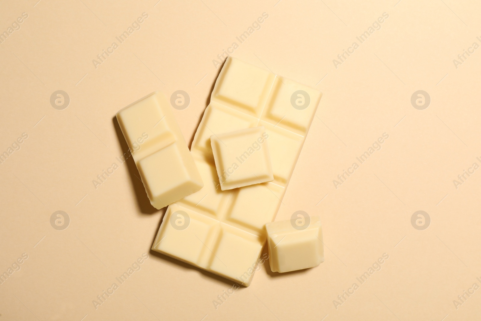 Photo of Delicious white chocolate on beige background, flat lay