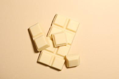 Delicious white chocolate on beige background, flat lay
