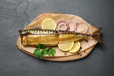 Photo of Tasty smoked fish on black table, top view