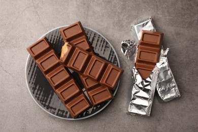 Photo of Tasty chocolate bars on grey table, flat lay