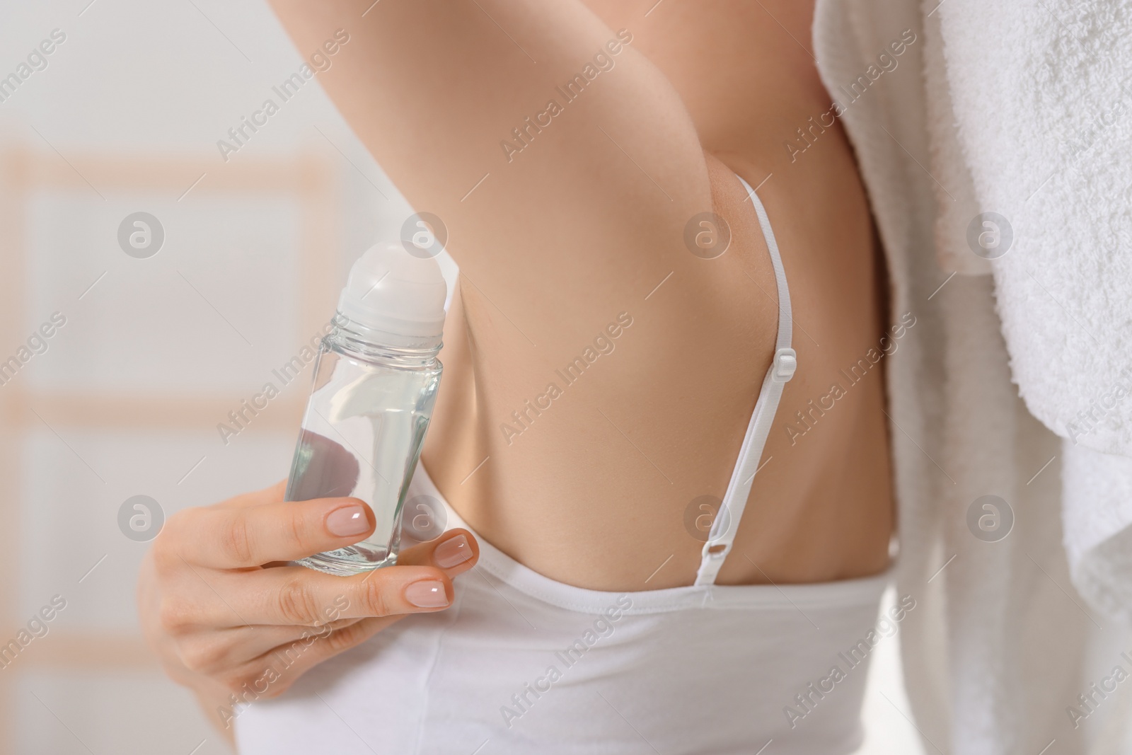 Photo of Woman applying deodorant in bathroom, closeup view