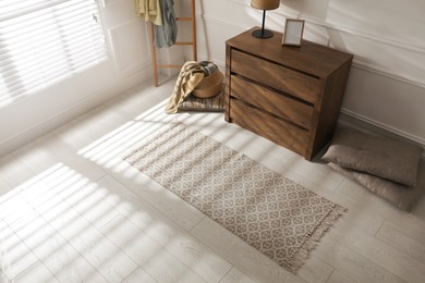 Stylish rug with pattern on floor in room, above view