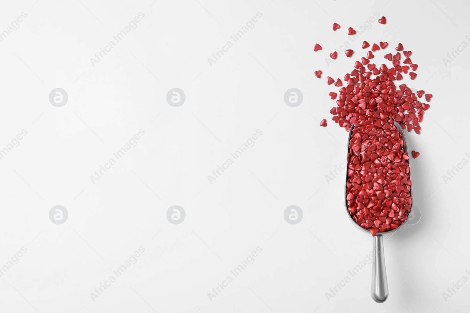 Photo of Bright heart shaped sprinkles in scoop on white background, top view
