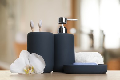 Image of Bath accessories. Different personal care products and flower on wooden table in bathroom