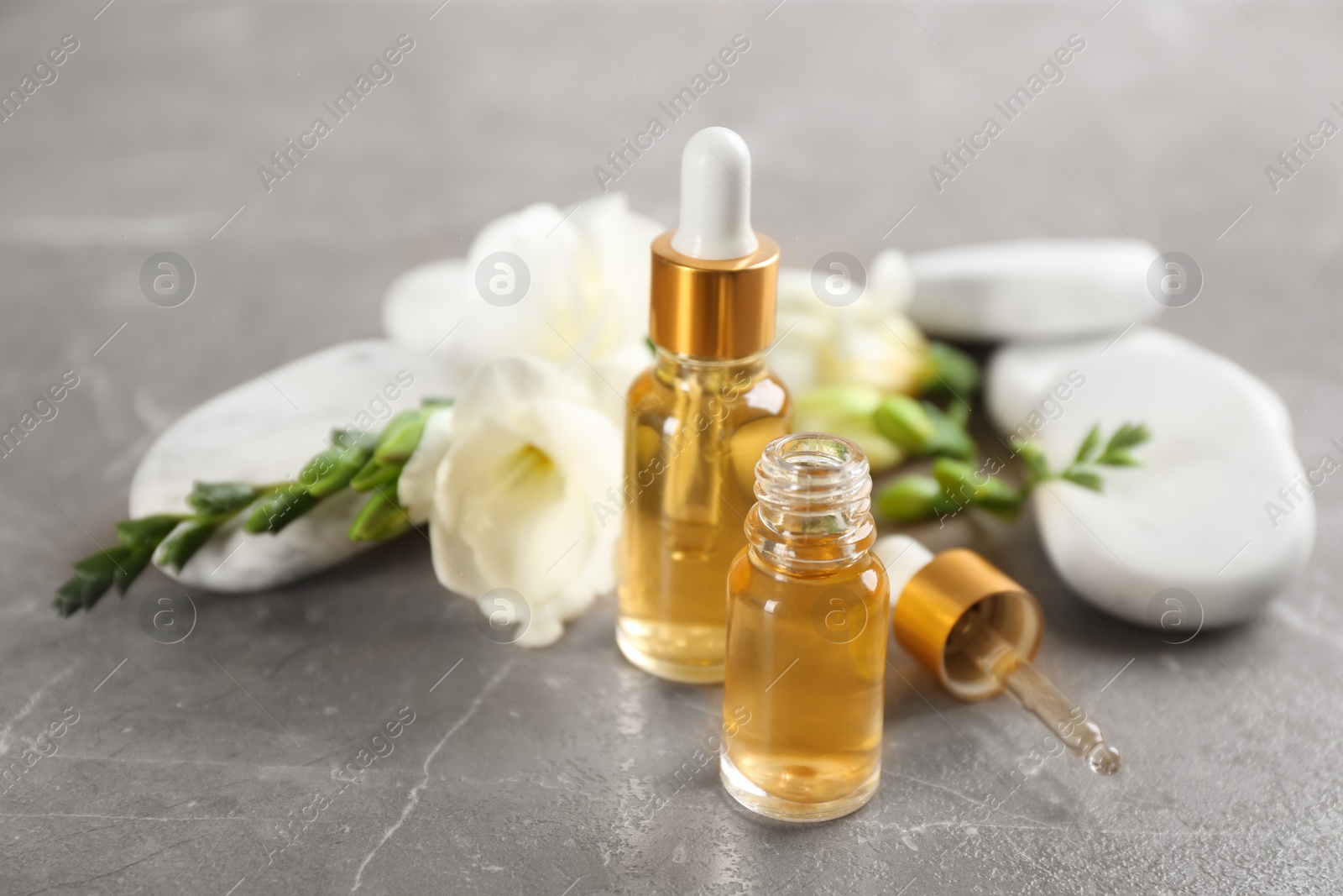 Photo of Beautiful composition with essential oil and spa stones on table