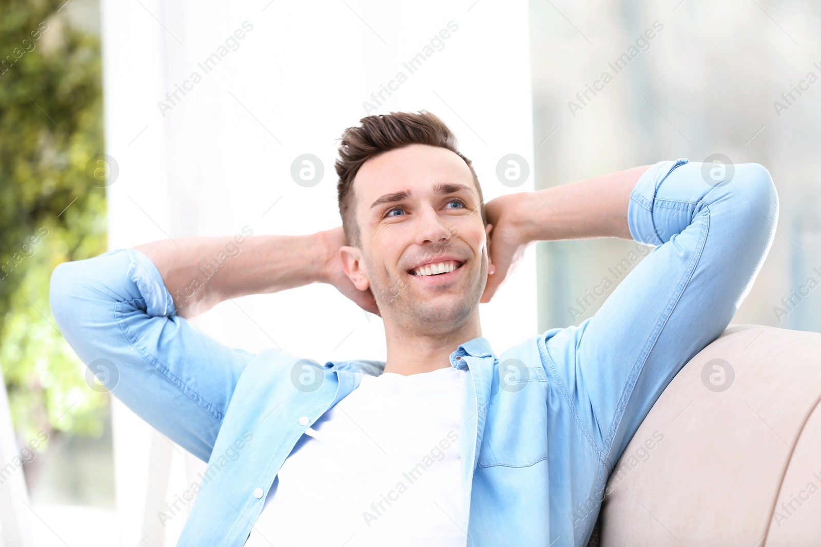 Photo of Young man resting on sofa at home