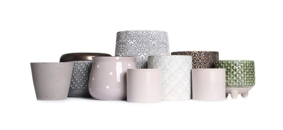 Different stylish ceramic flowerpots on white background