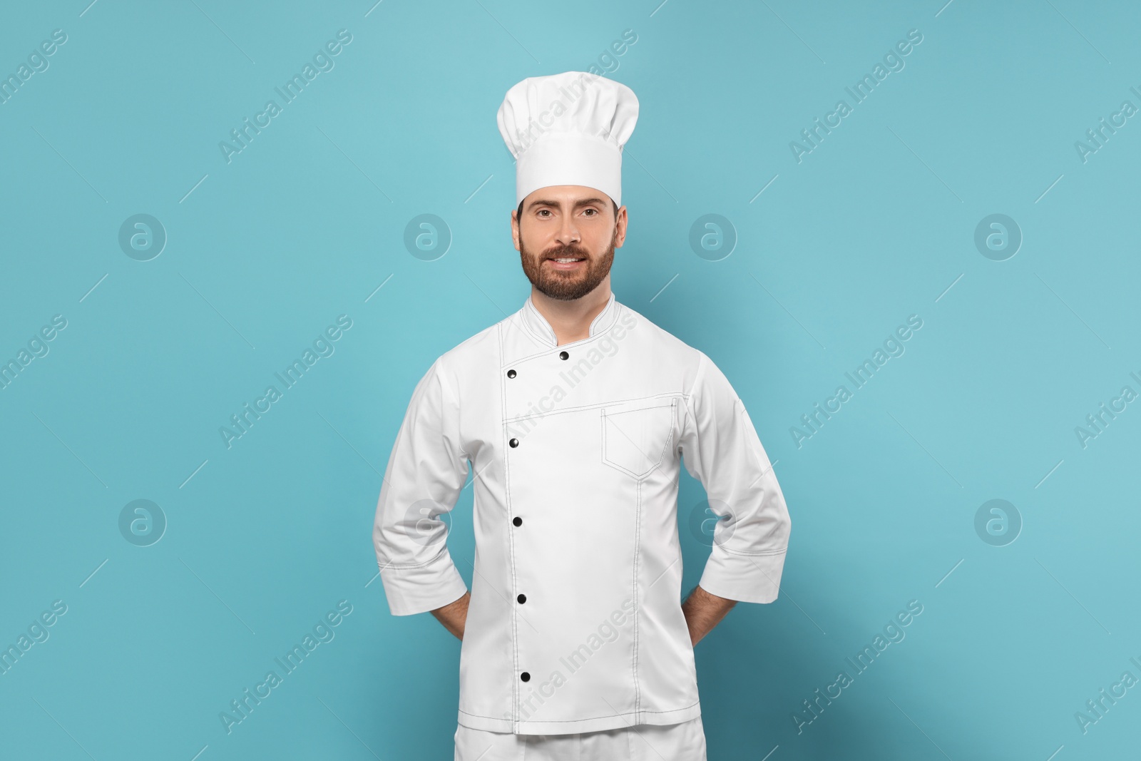 Photo of Smiling mature chef on light blue background