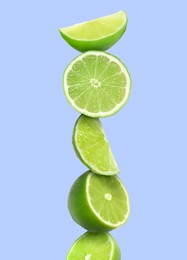 Image of Stacked cut limes on light pale blue background