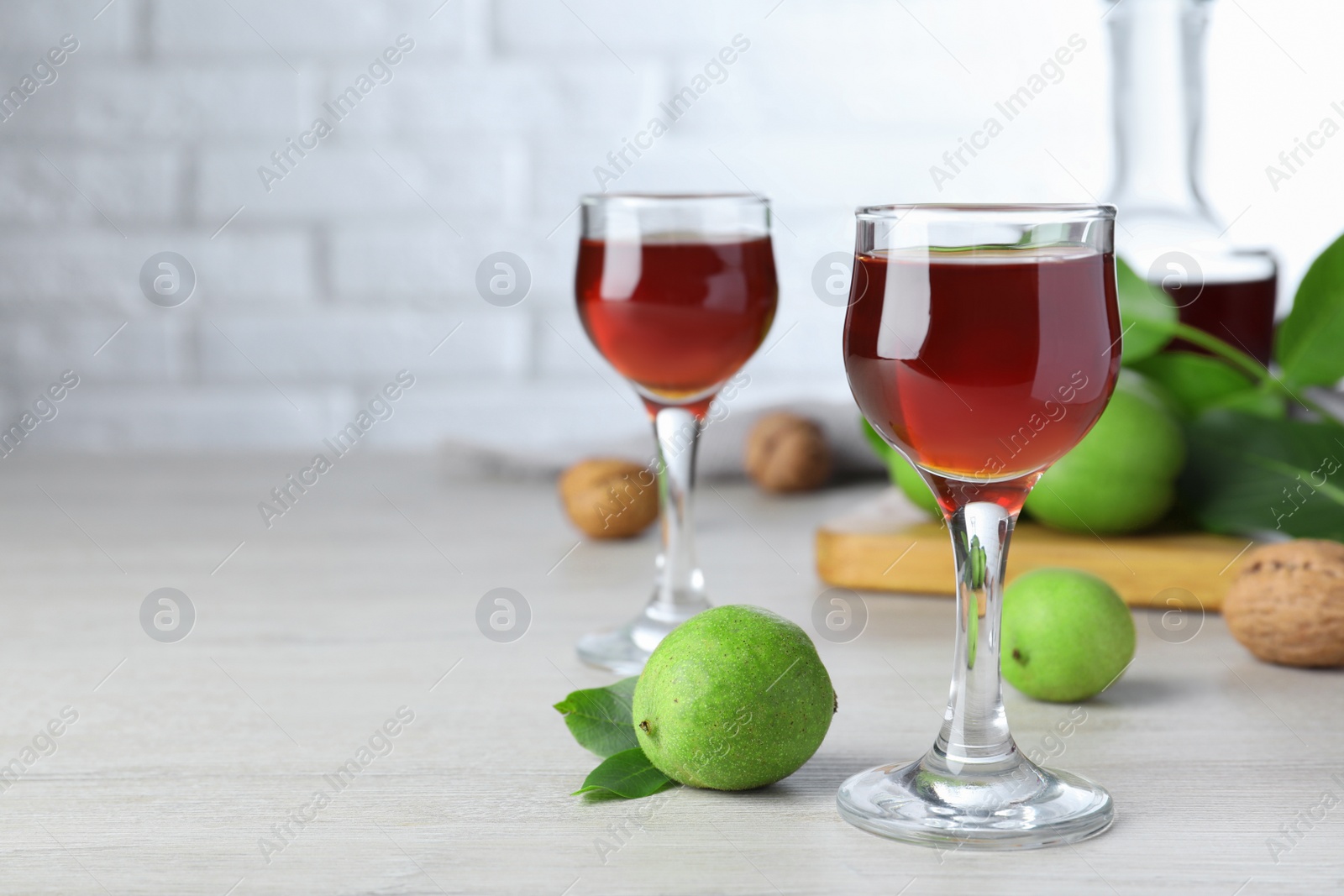 Photo of Delicious liqueur and fresh walnuts on wooden table