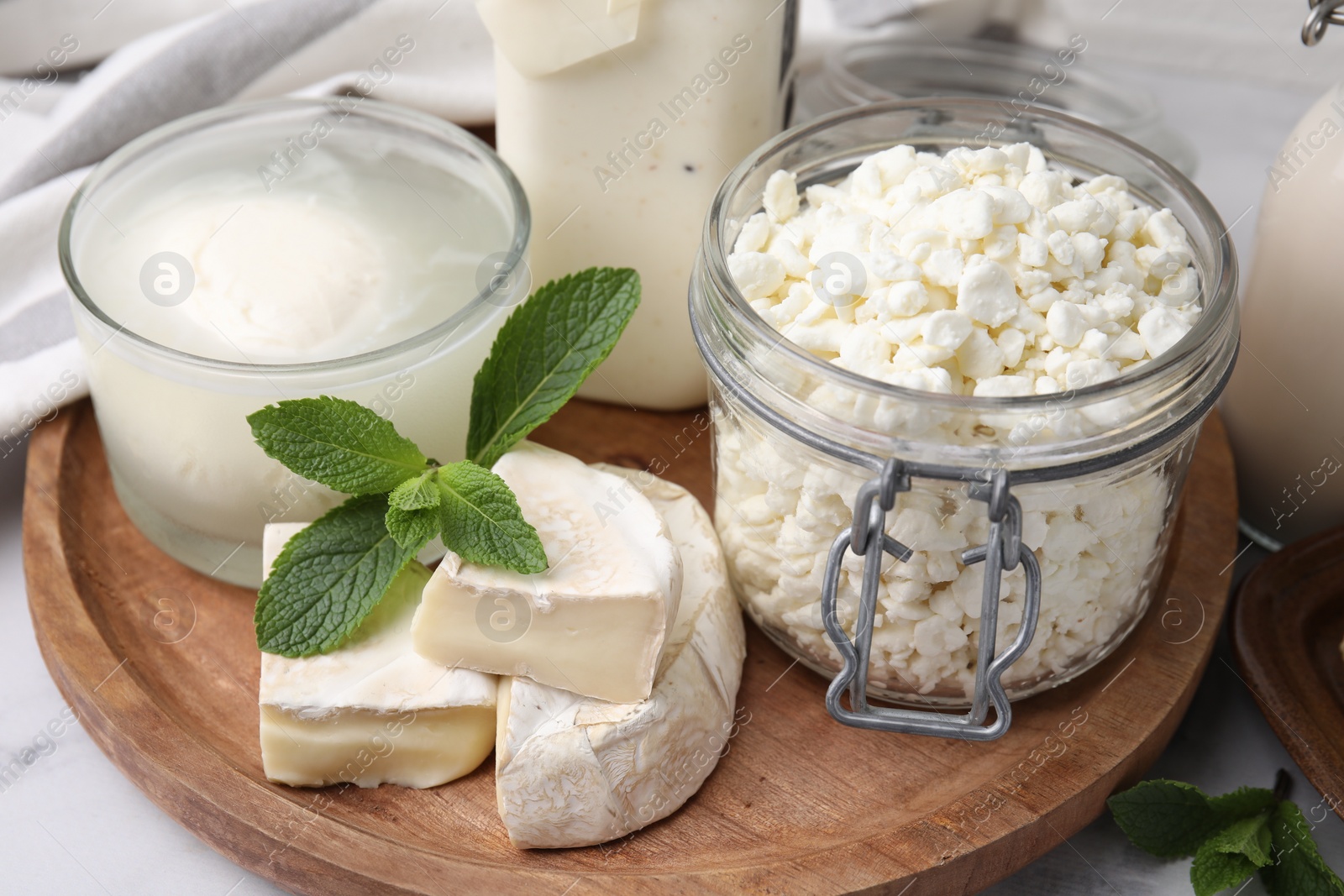 Photo of Different dairy products and mint on table