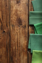 Photo of Different kitchen napkins on wooden table, flat lay. Space for text