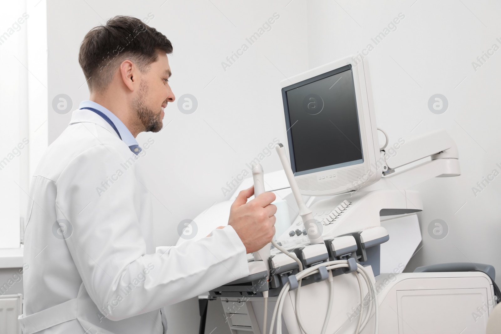 Photo of Sonographer operating modern ultrasound machine in clinic