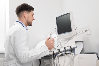 Sonographer operating modern ultrasound machine in clinic