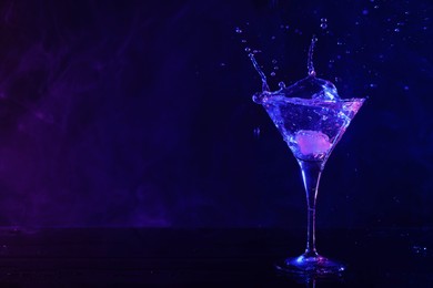 Photo of Martini splashing out of glass in neon lights, space for text