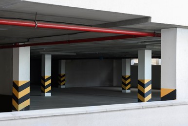 Photo of Empty car parking garage with warning stripes on columns
