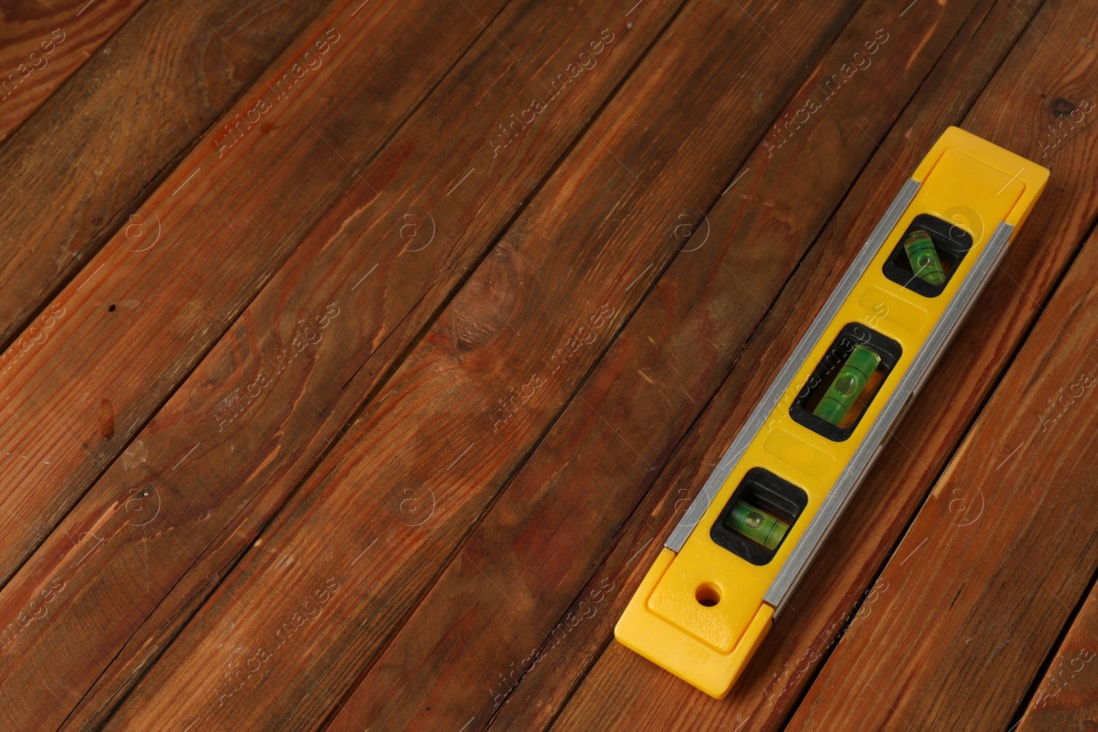 Photo of Building level on wooden table. Space for text