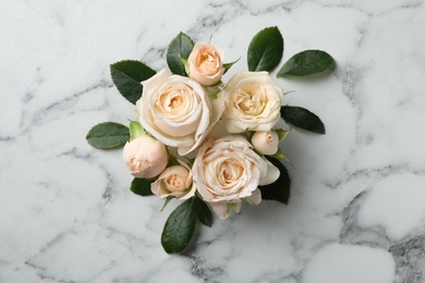 Photo of Beautiful roses on marble background, top view