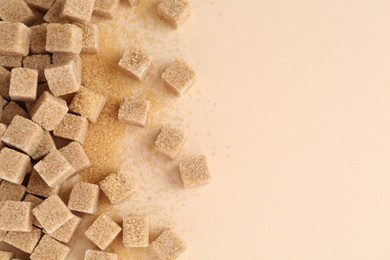 Photo of Brown sugar cubes on beige background, top view. Space for text