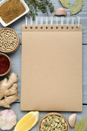 Blank recipe book and different ingredients on grey wooden table, flat lay. Space for text