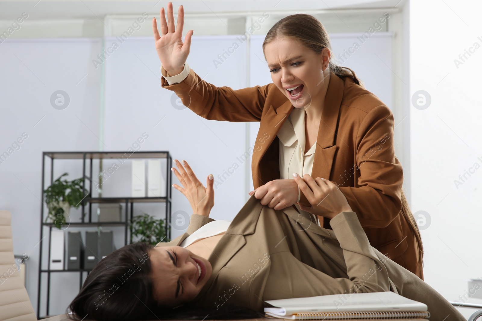 Photo of Emotional colleagues fighting in office. Workplace conflict