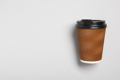 Photo of Takeaway paper coffee cup on light grey background, top view. Space for text