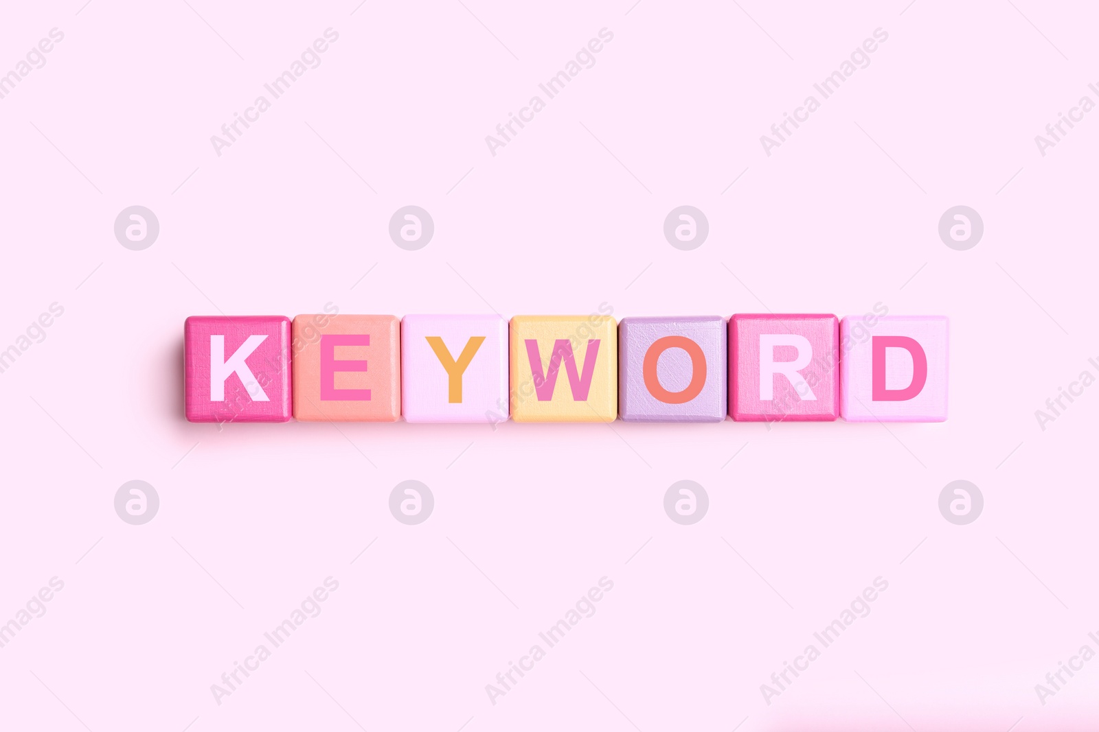 Photo of Colorful cubes with word KEYWORD on pink background, flat lay