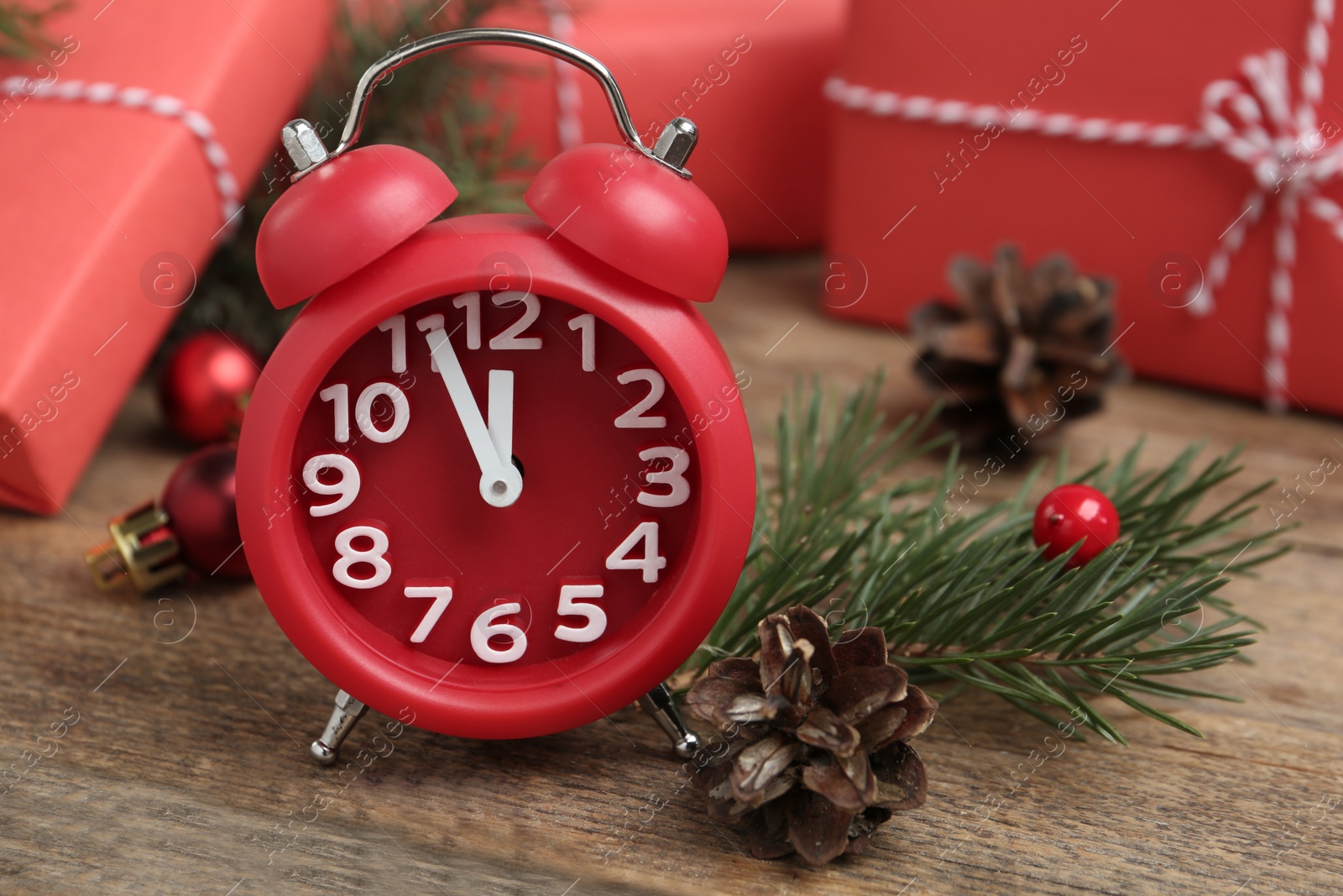 Photo of Beautiful composition with alarm clock and Christmas gifts on wooden table, closeup. Boxing day