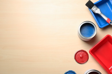 Photo of Flat lay composition with paint cans and brush on wooden background. Space for text