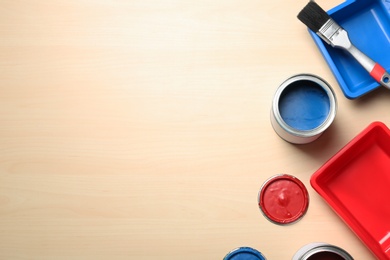 Flat lay composition with paint cans and brush on wooden background. Space for text