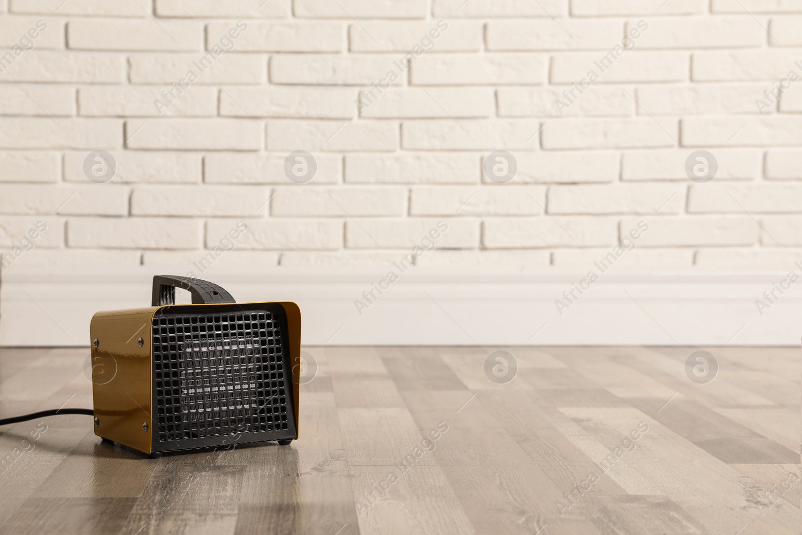 Photo of New modern electric heater on floor in room, space for text