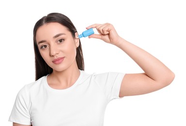 Photo of Young woman using ear drops on white background