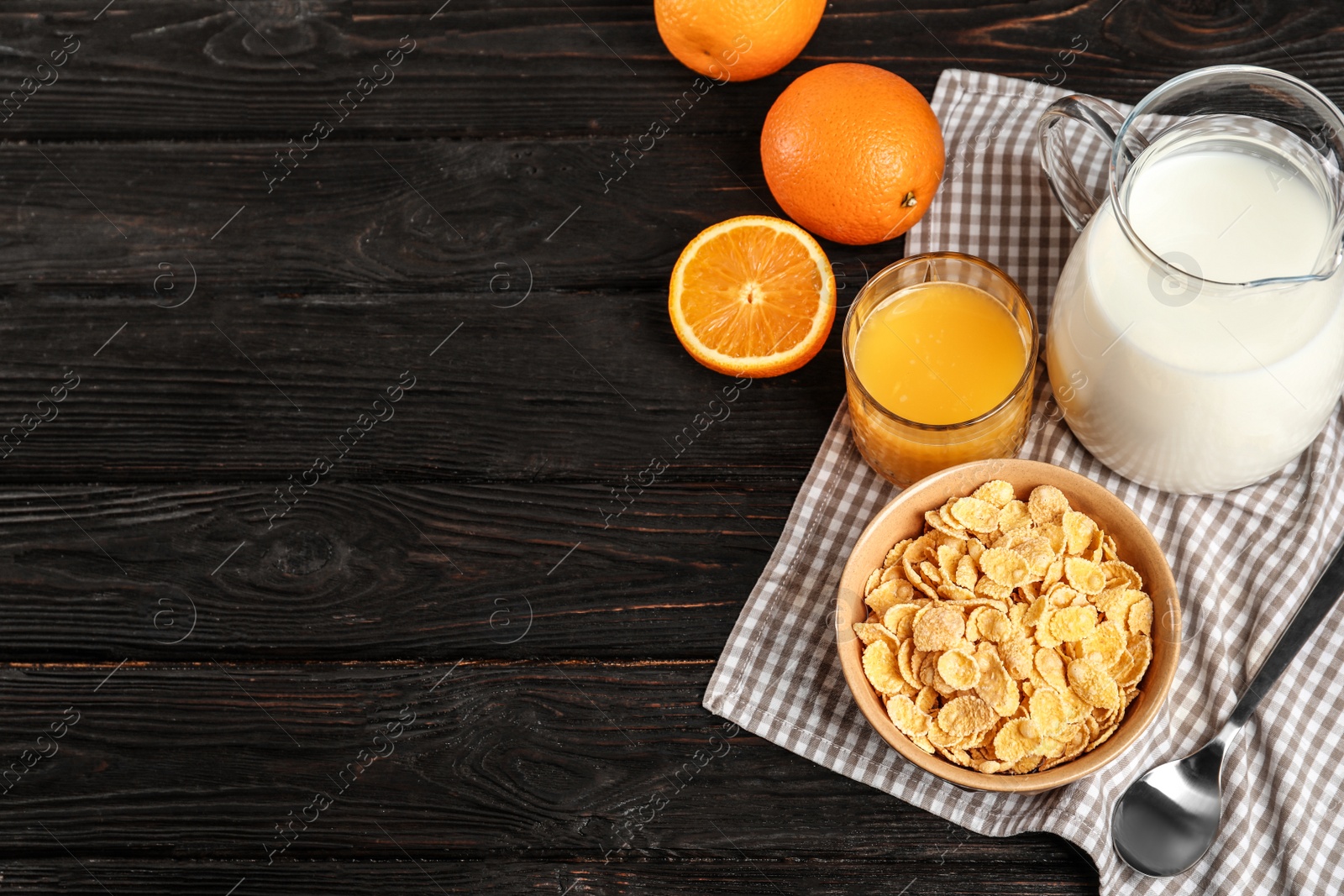 Photo of Bowl with healthy cornflakes for breakfast served on dark table. Space for text