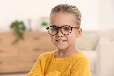 Photo of Portrait of cute little girl wearing glasses indoors