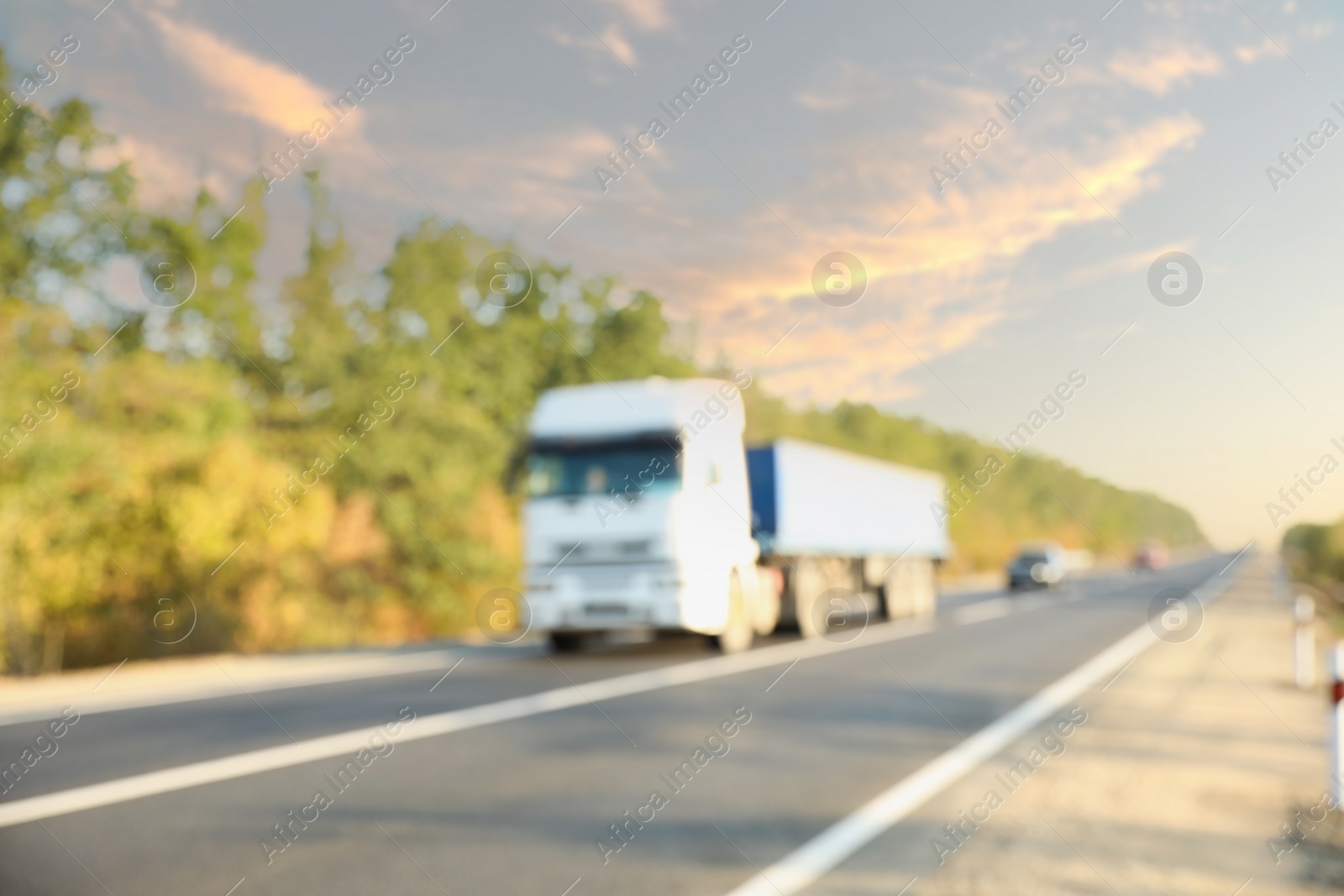 Photo of Blurred view of asphalt highway with truck. Road trip