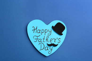 Photo of Greeting card with words HAPPY FATHER'S DAY on blue background, top view