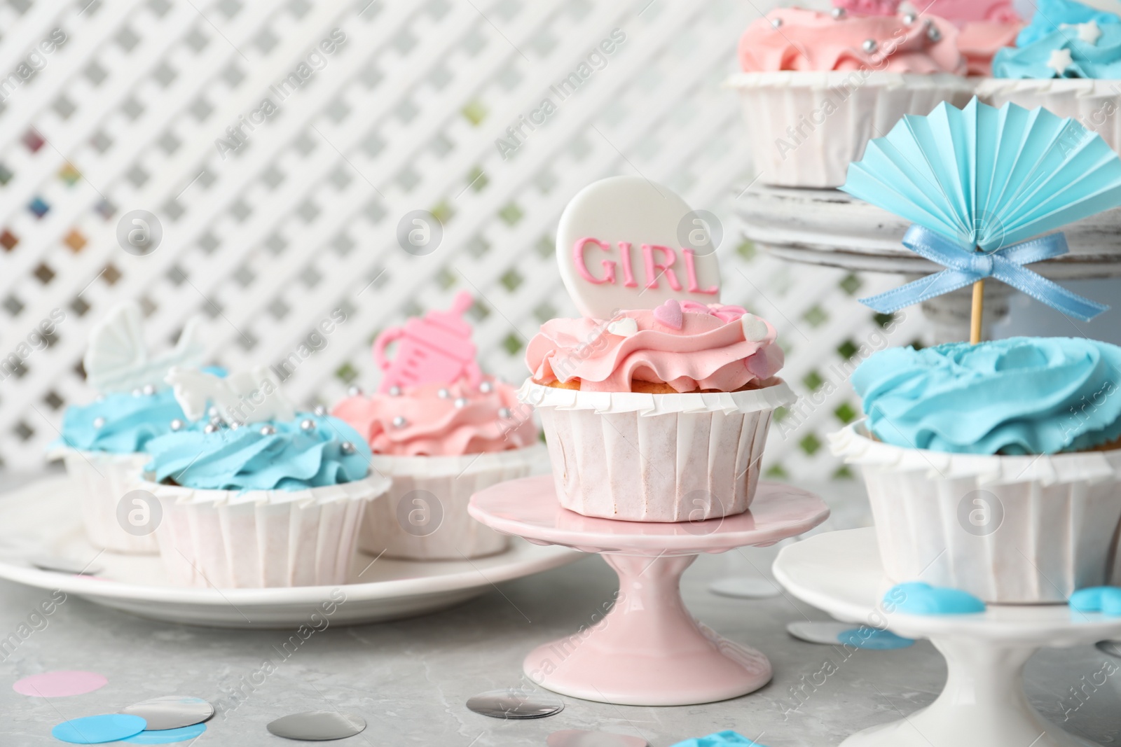 Photo of Delicious cupcakes with light blue and pink cream for baby shower on grey table