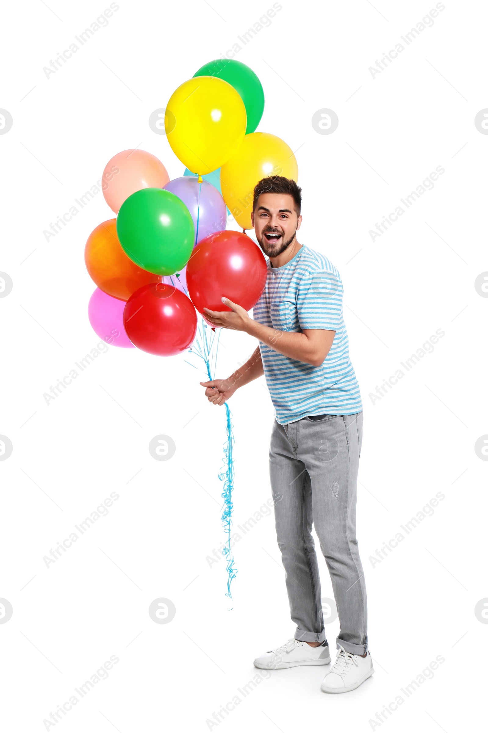 Photo of Emotional young man holding bunch of colorful balloons on white background