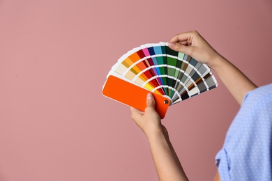 Photo of Female interior designer with palette samples on color background, closeup. Space for text