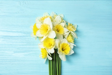 Photo of Bouquet of daffodils on wooden background, top view. Fresh spring flowers