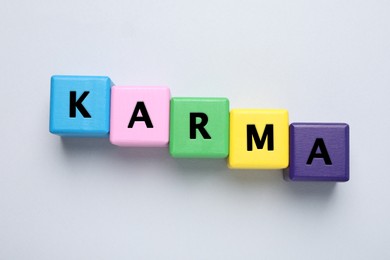 Photo of Word Karma made of colorful cubes with letters on white background, top view