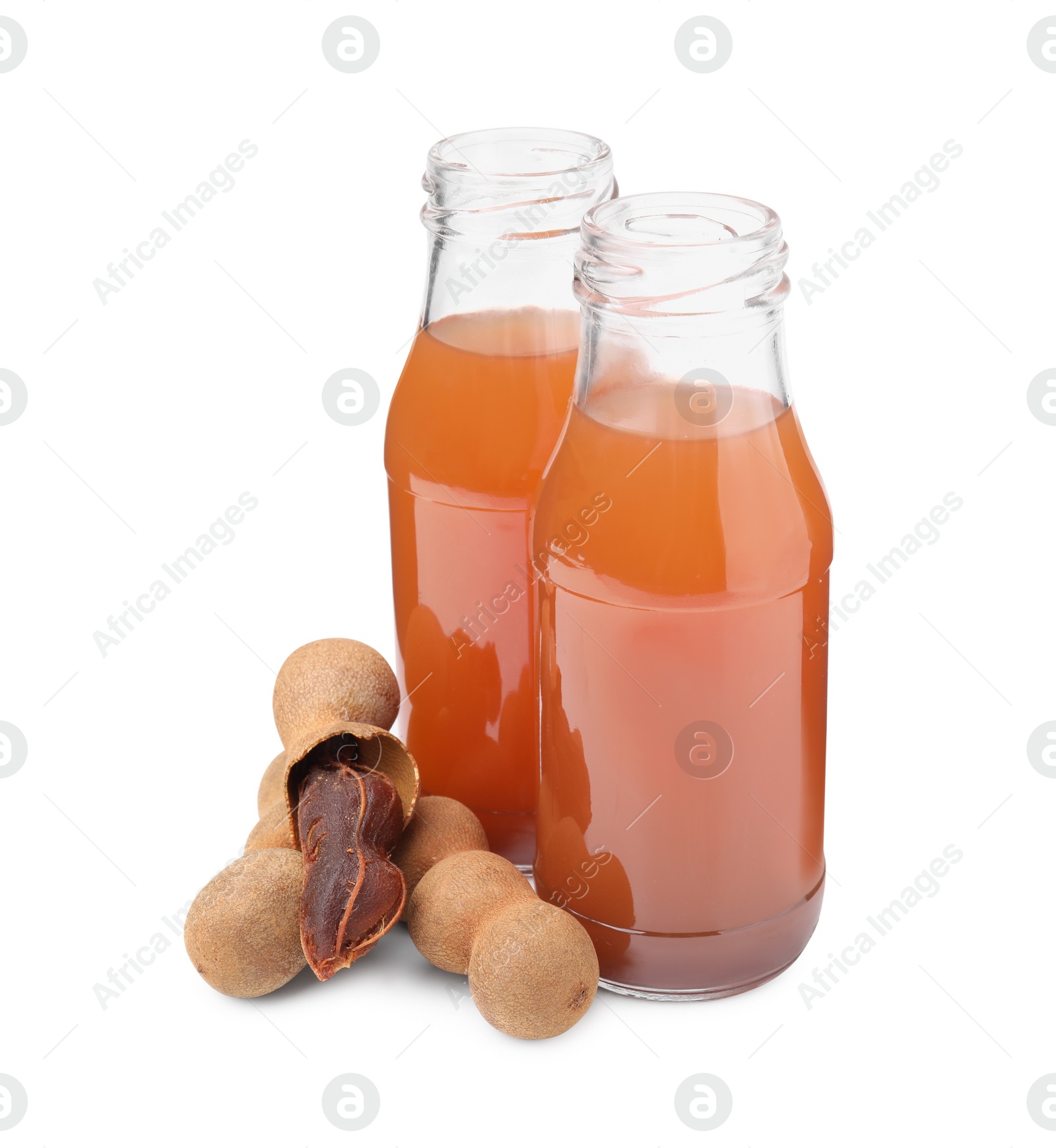 Photo of Bottles of tamarind juice and fresh fruits isolated on white